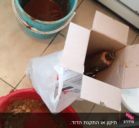 דלי עם חלודה, קרטון עם חלקי דוד שמש